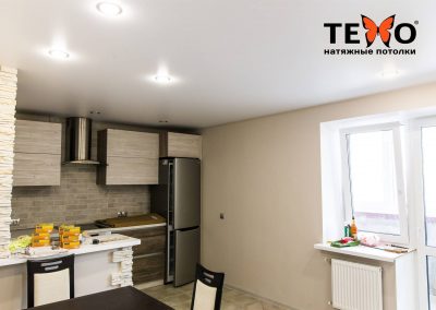 Белый сатиновый натяжной потолок с точечными светильниками в светлой кухне