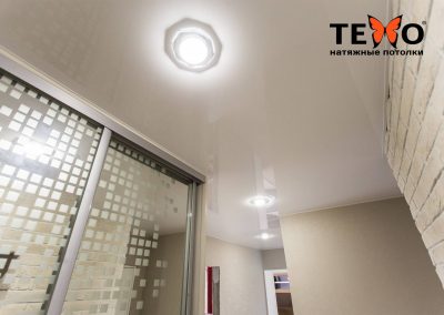 Белый глянцевый натяжной потолок с точечными светильниками в коридоре