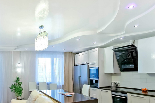 Многоуровневый натяжной потолок волна с точечной подсветкой в просторной кухне