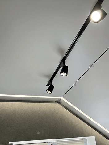 Мансарда частного дома с трековым освещением и скрытым карнизом